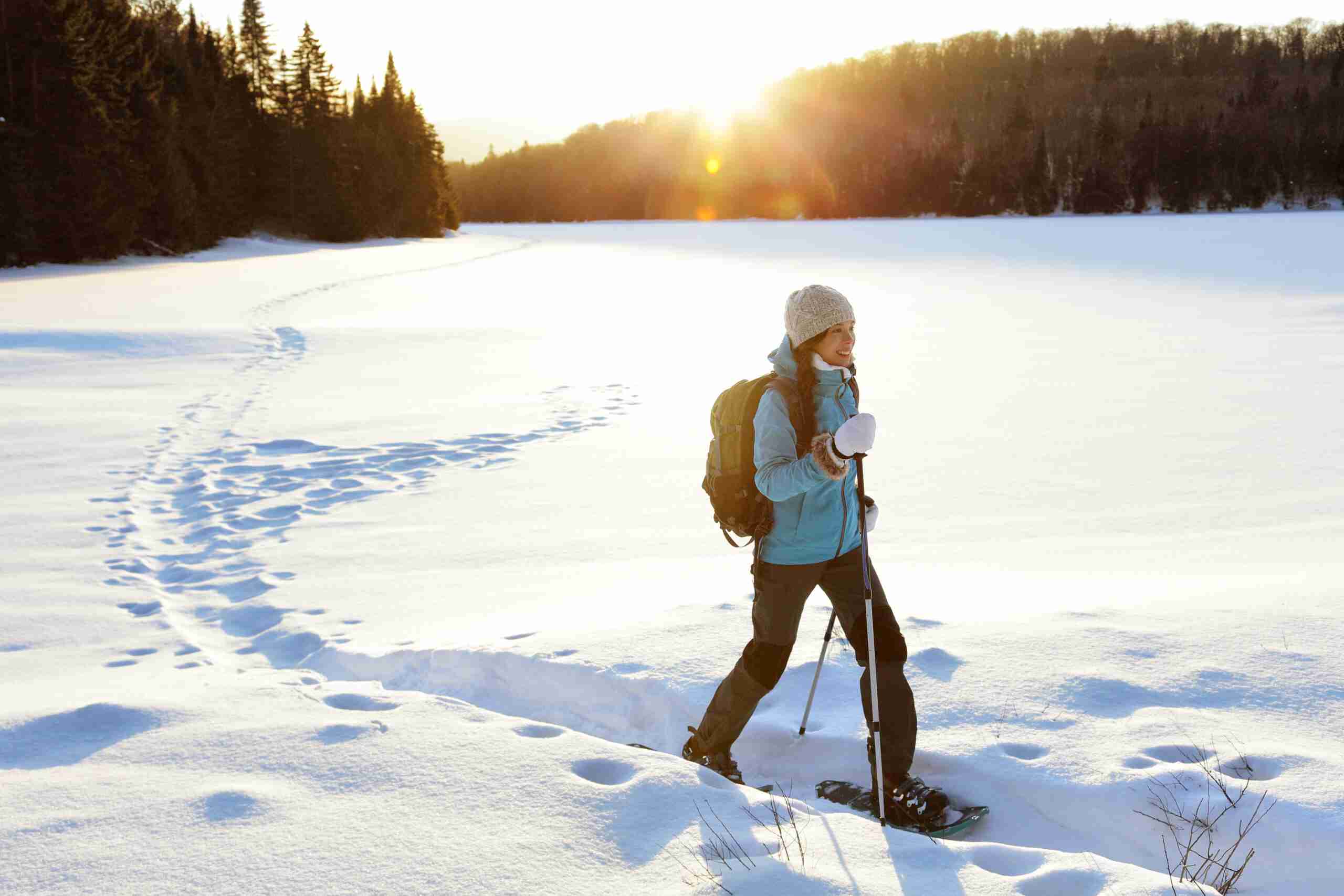 Winter hiking sport activity woman snowshoeing woman walking pain-free because of sports and injury rehabilitation minnesota