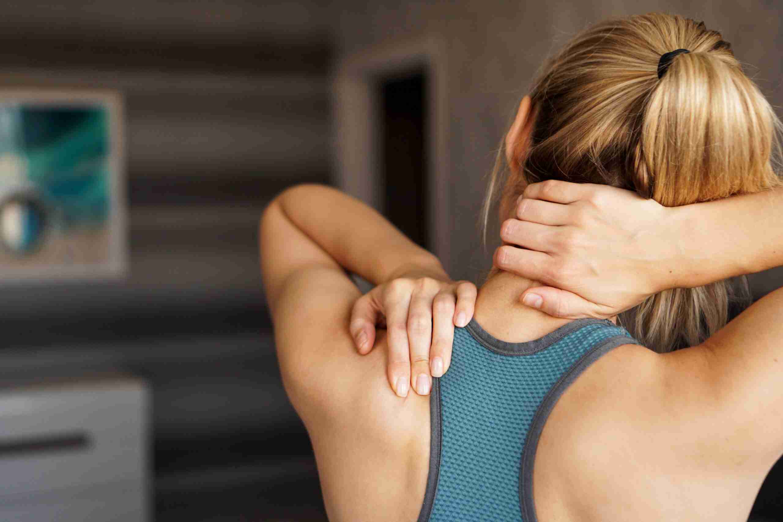 woman experiencing neck pains due to work injuries