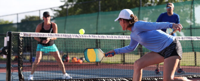 group of people playing pickleball on an outdoor court