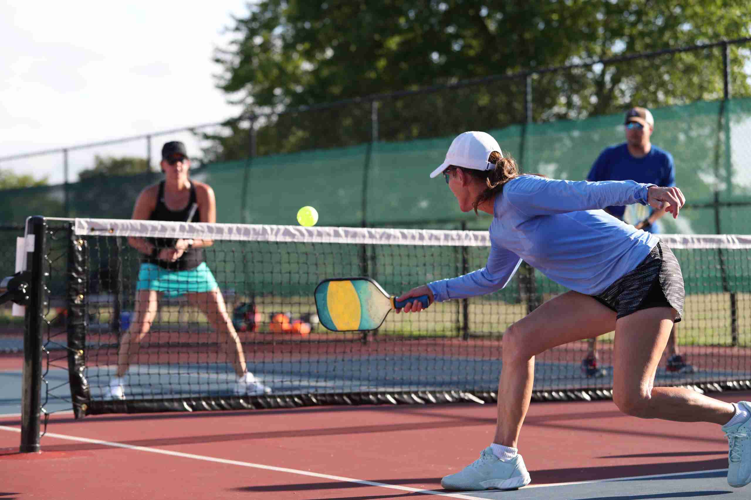 group of people playing pickleball on an outdoor court